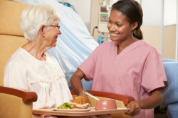 nurse giving food to an elderly woman